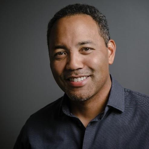 Headshot of Ray Austin in front of a dark gray background