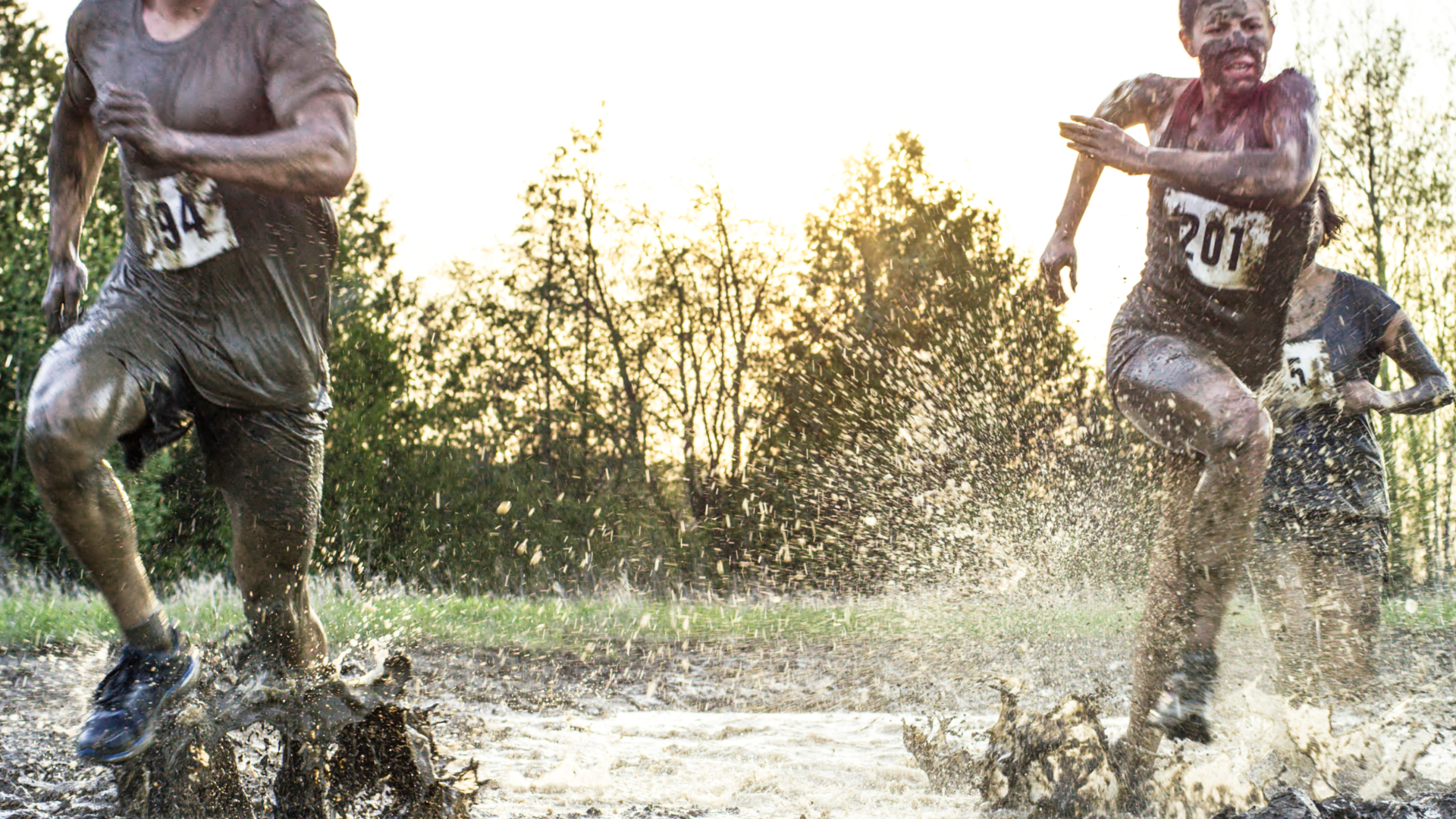 People running a race through the mud.